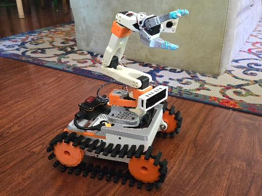 Tank-tread robot with arm on a home floor